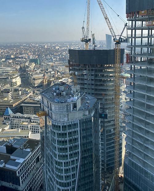 Ausblick auf zwei im Neubau befindliche Wolkenkratzer, dahinter Frankfurt, in weiter Ferne Europäische Zentralbank